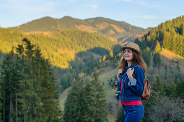 The woman  traveler is admires of landscapes during a mountain hiking.
