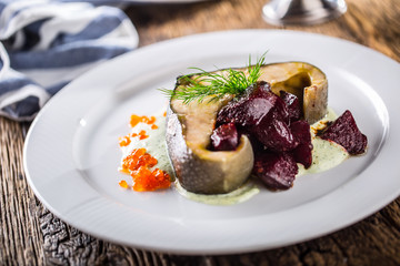 Sturgeon fillet with caviar beetroot and dill on plate in hotel or restaurant