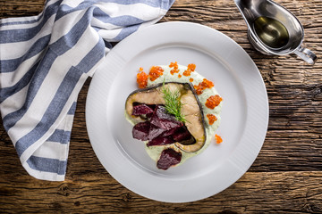 Sturgeon fillet with caviar beetroot and dill on plate in hotel or restaurant