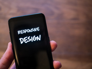 Responsive design mobile concept. Black smartphone display text with concept of internet web pages.