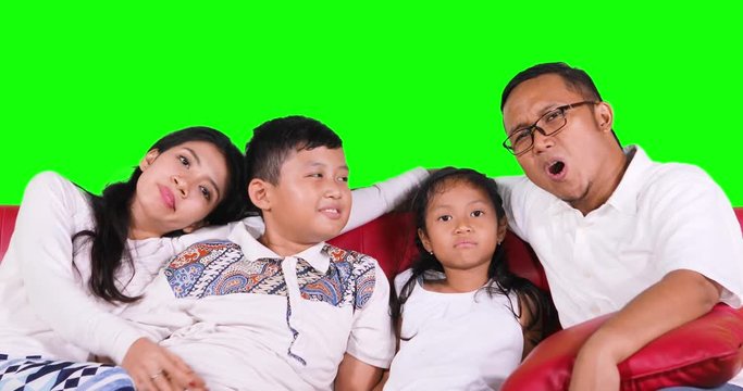 Bored Asian family watching tv together and find a good channel, shot in 4k resolution with green screen background