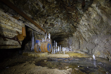 Underground abandoned ore mine shaft tunnel gallery with ice stalactites stalagmites
