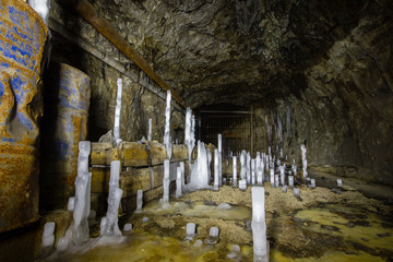 Underground abandoned ore mine shaft tunnel gallery with ice stalactites stalagmites