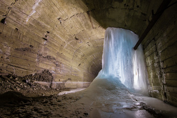 Underground abandoned ore mine shaft tunnel gallery with ice stalactites stalagmites