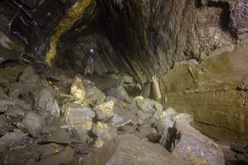 Underground abandoned ore mine shaft tunnel gallery with miner