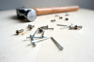 Nails, screws, and a hammer on home improvement construction site
