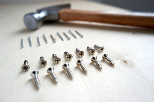 Nails, screws, and a hammer on home improvement construction site