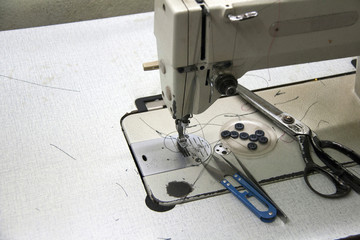 Sewing accessories on the Sewing machine, Includes forceps, Scissors, Scissors Clippers and buttons. it is a garment job for clothes and fashion.