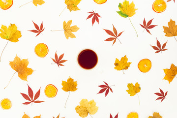Autumn colorful maple leaves and tea cup on white background. Flat lay, top view.