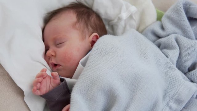 Cute newborn baby sleeping in swinging cradle