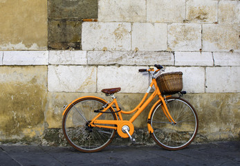 Fototapeta na wymiar Orange bicycle park near the wall