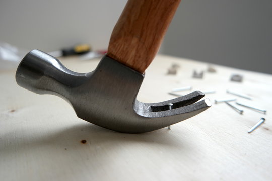 A hammer pulling out a nail on wood at a home improvement construction