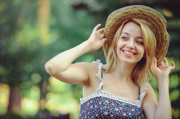 Beauty Summer model girl with bright flowers happy forest. style leisure.white lady in a straw hat. A nice face with a smile and a mystery. place for banner and advertisement