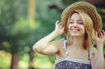 Beauty Summer model girl with bright flowers happy forest. style leisure.white lady in a straw hat. A nice face with a smile and a mystery. place for banner and advertisement