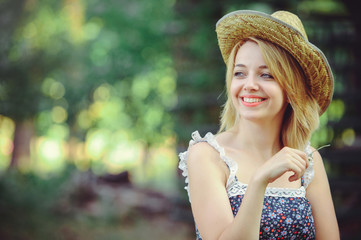 Beauty Summer model girl with bright flowers happy forest. style leisure.white lady in a straw hat. A nice face with a smile and a mystery. place for banner and advertisement