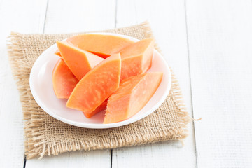 White wooden floor with ripe papaya in plate,Fresh papaya sliced on a wooden table, healthy food concept