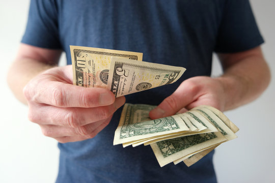 Man counting US dollar bills cash on hand