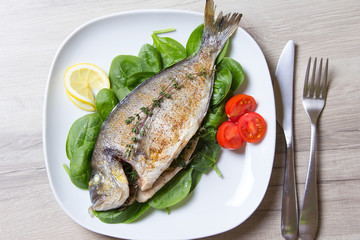 Baked Dorado with spinach and pesto sauce. Close-up. Selective focus.