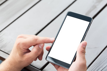 Man holding smart mobile phone on wooden table background