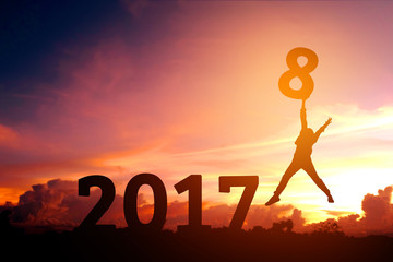 Silhouette young man jumping to 2018 new year