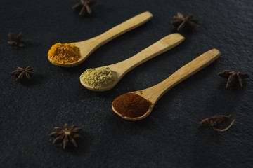 Star anise with various spices powder in wooden spoon