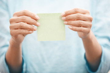 Woman holding adhesive note