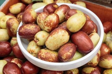 Closeup of fresh jujube fruit in a bowl.