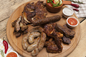 fried pork sausage and pork knuckle on the kitchen wooden table, meat dishes