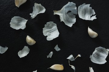 Garlics and peeled on black background