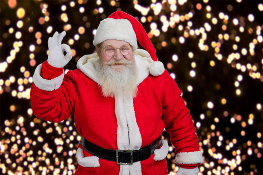 Santa showing ok gesture. Santa Claus showing hand okay sign on Ney Year lights background.