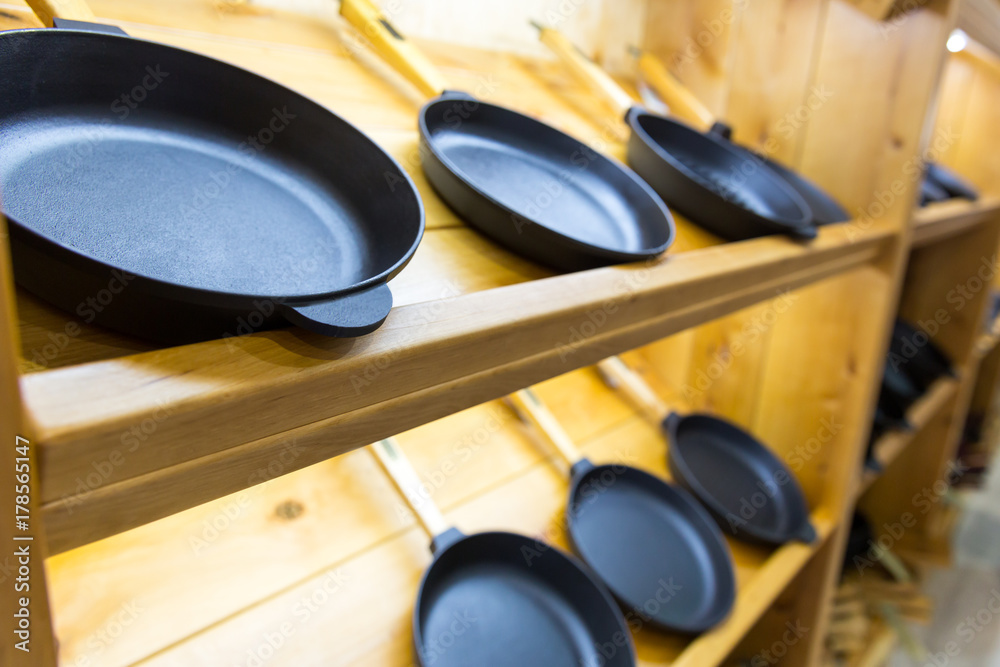 Wall mural Frying pans on wooden shelf, cooking tools