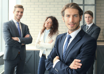 Businessman with colleagues in the background in office.