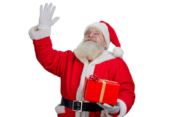 Santa Claus waving with hand, portrait. Santa Claus with real beard holding gift box and waving with hand on white background. Realistic Santa Claus doing gesture.