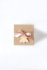Christmas gift box of crafting wooden Christmas tree and a pink satin ribbon on white background