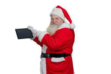 Santa Claus with computer tablet. Senior Santa Claus holding digital computer tablet and pointing on blank touch screen with index finger, white background.