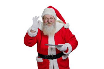 Santa Claus with digital tablet. Senior Santa Claus is realizing kids wishes making a magic on white background. Santa Claus with touch screen tablet, studio shot.