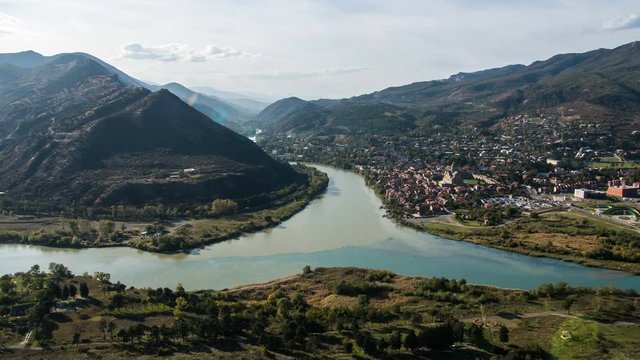 4K Timelapse. View from Jvari Monastery on the city Mtskheta and confluence of the Aragvi and Kura rivers. Afternoon, blue sky, running clouds, mountains.
