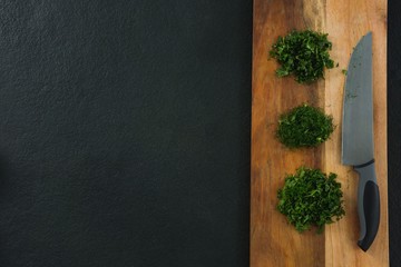 Fototapeta premium Chopped herbs with knife on chopping board