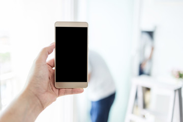 hand use smartphone with background of worker in white room