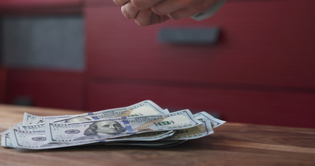 side shot of man counting dollars on wood table