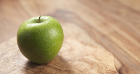 green apple on wood board