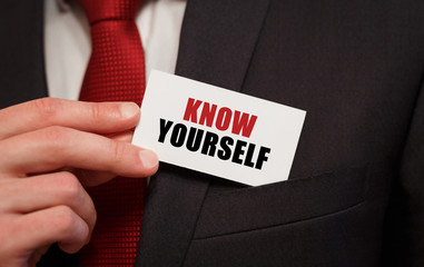 Businessman putting a card with text KNOW YOURSELF in the pocket