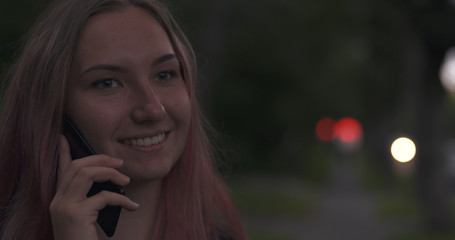 female teen talking on the phone on the street at night