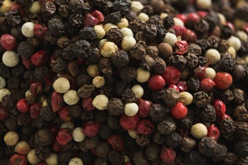 Black pepper and white pepper on white background