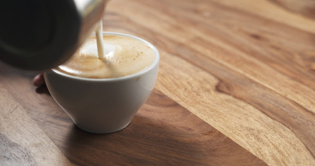 steamed milk pour into coffee cup to make cappuccino