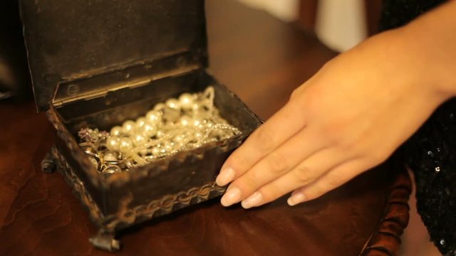 beautiful woman opens the box. well-groomed woman's hand opens a box with jewelery. part of the body. close-up