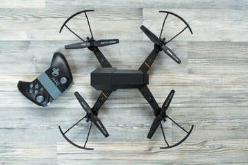 Drone and control panel on gray wooden background