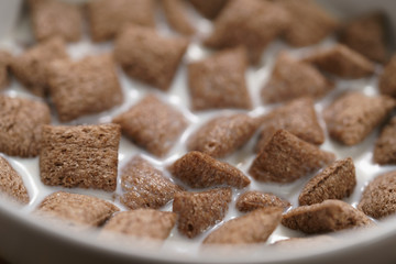 poured with milk chcolate cereal pillow in white bowl
