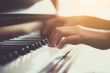 Close up of happy woman's hand playing the piano in the morning. - 178570765