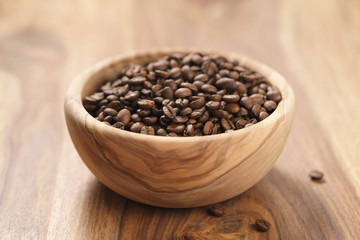 roasted coffee beans in wood bowl on table
